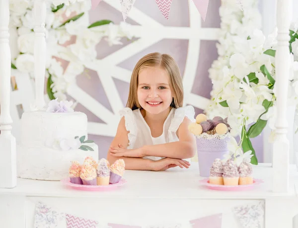 Petite fille tenant un gâteau sucré dans la barre de bonbons — Photo