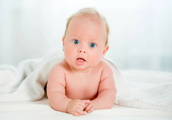 Bebé recién nacido con hermosos ojos azules acostados en el vientre —  Fotos de Stock