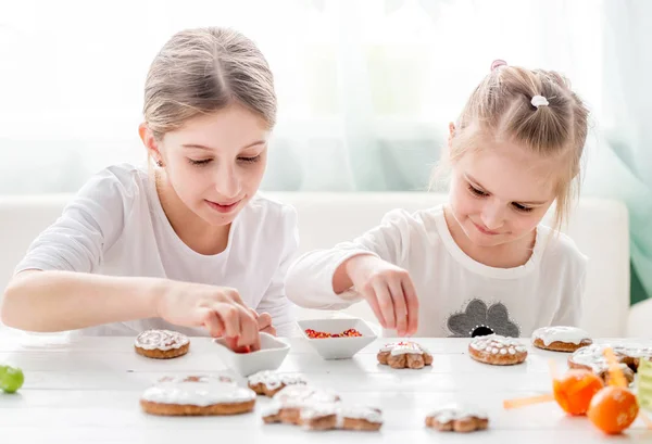 Słodkie dziewczyny dekorowanie ciasteczek Wielkanoc — Zdjęcie stockowe