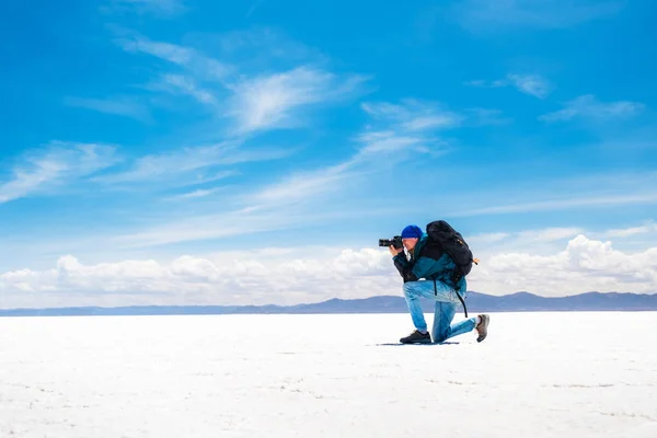 Fotógrafo tomando fotos bajo el sol Salar de Uyuni — Foto de Stock