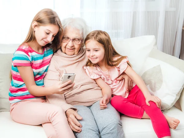 Netas sorridentes com bisavó — Fotografia de Stock