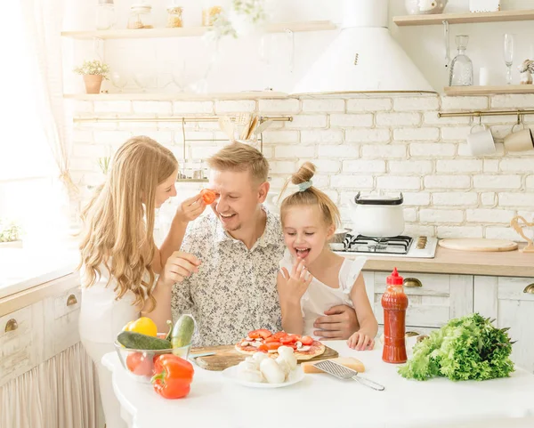 dad with daughters preparing pizza