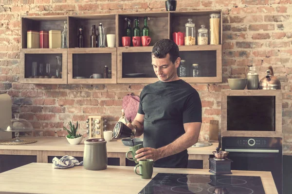 yakışıklı adam taze yapılmış kahve bardak içine dökülen.