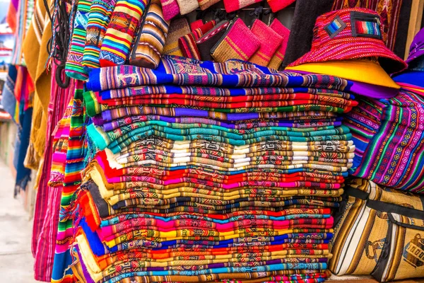 Una gran cantidad de diferentes cubiertas de tela de colores en la tienda de recuerdos en Bolivia —  Fotos de Stock