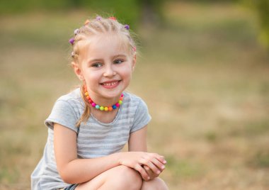 bir yaz parkta küçük kız gülümseyerek