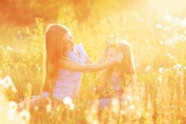 İki küçük kız kardeş çelenk çiçek örgü