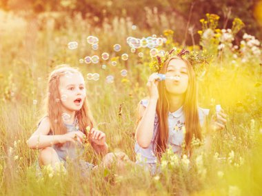 İki küçük kız kardeşi sabun köpüğü üfleme