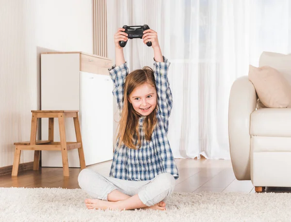 Маленькая девочка с радостью держит джойстик — стоковое фото