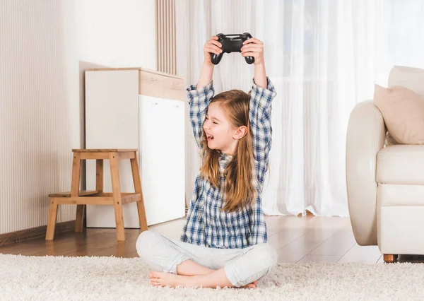 Lttle chica alegremente sosteniendo joystick —  Fotos de Stock