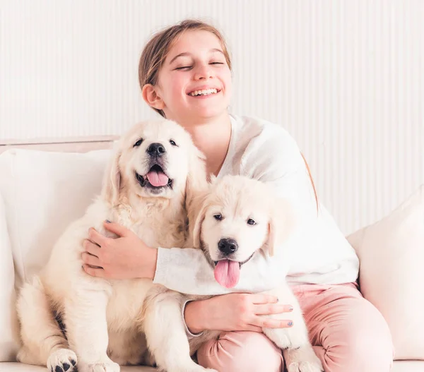 Chica sonriente abrazando cachorros — Foto de Stock