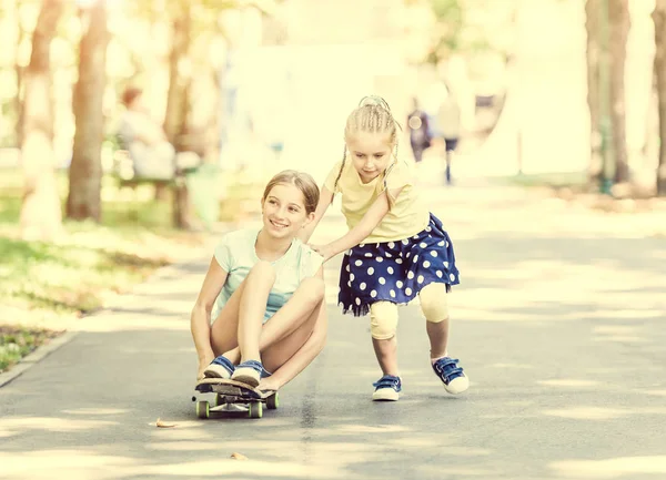 두 명의 작은 자매는 스케이트 보드와 재생 — 스톡 사진
