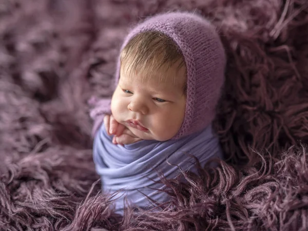 Malé roztomilé dítě sedí na tmavě růžové deky — Stock fotografie