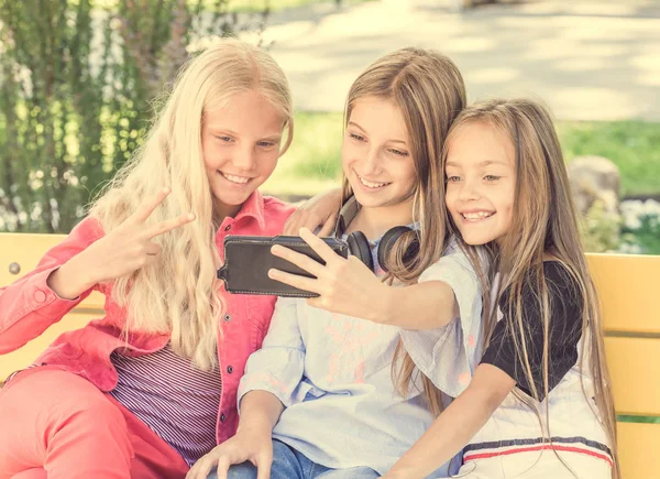 Les filles font selfie à l'extérieur tout en étant assis sur des longboards — Photo