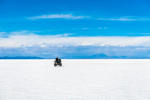 Солнечный пейзаж Салар-де-Уюни в Боливии с байкером — стоковое фото