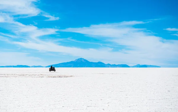 Sunshine cenário de Salar de Uyuni na Bolívia com motociclista andando sobre — Fotografia de Stock