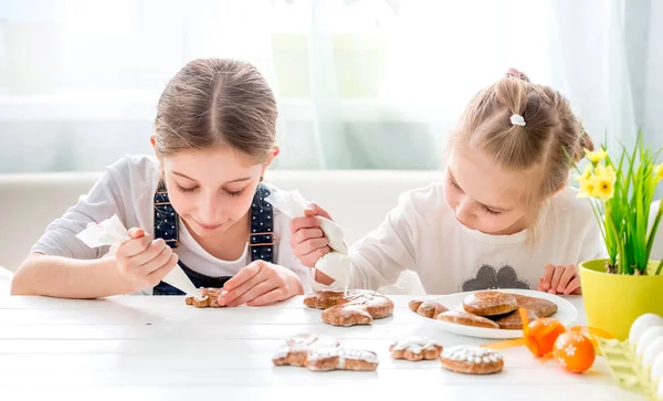 Dziecko dziewczynka dekorowanie ciasteczek Wielkanoc — Zdjęcie stockowe