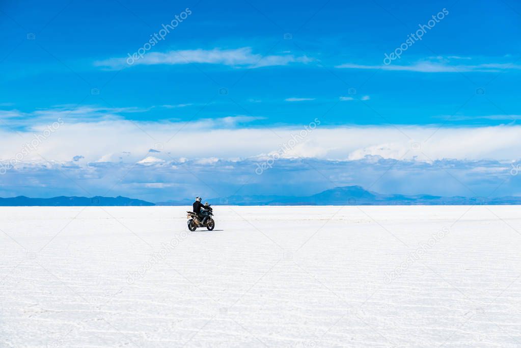 Sunshine scenery of Salar de Uyuni in Bolivia with biker riding over