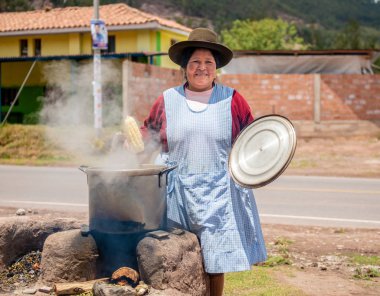 Peru village - 12 October 2018 : Woman cooking korn clipart