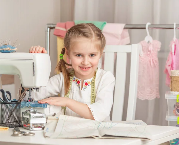 Klein meisje in een workshop naaien — Stockfoto