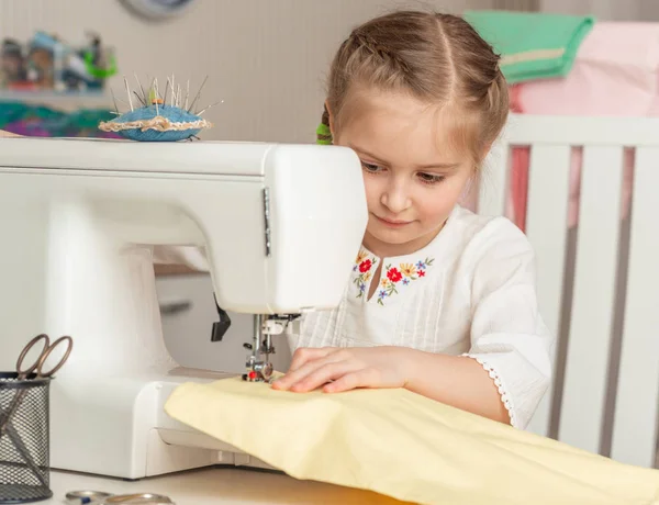 Kleines Mädchen in einer Nähwerkstatt — Stockfoto