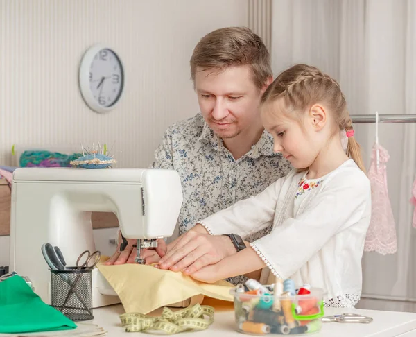 Kleines Mädchen und ihr Vater in einer Nähwerkstatt — Stockfoto