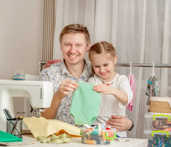 Kleines Mädchen und ihr Vater in einer Nähwerkstatt — Stockfoto