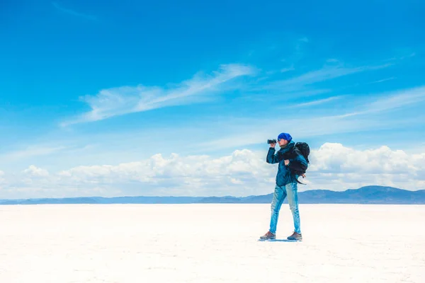 Tourist taking photo in sunshine Salar de Uyuni — Stock Photo, Image