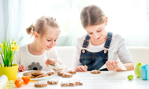 Dziecko dziewczynka dekorowanie ciasteczek Wielkanoc — Zdjęcie stockowe