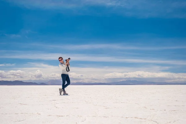 Lachende meisje met camera in Salar de Uyuni — Stockfoto