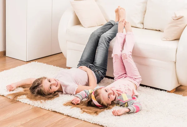 Meninas engraçadas descansando no chão — Fotografia de Stock