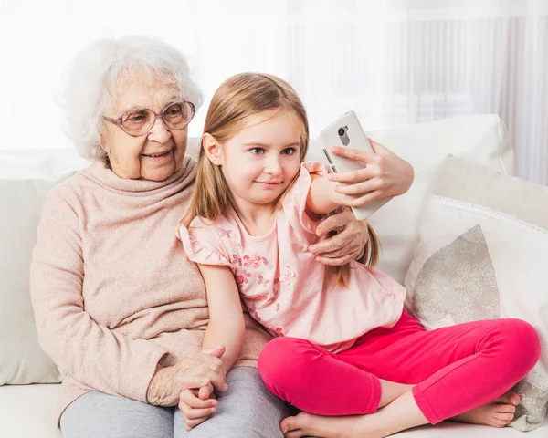 Nieta tomando selfie con bisabuela —  Fotos de Stock