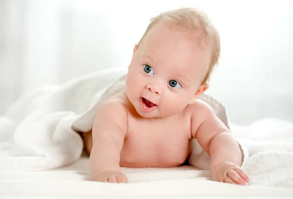 Bebé recién nacido con hermosos ojos azules acostados en el vientre —  Fotos de Stock