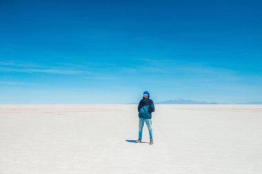 Salar de Uyuni gün ışığında yürüyen turist