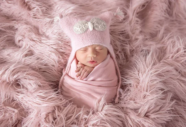 Nouveau-né en bonnet chapeau sur un tapis shaggy — Photo