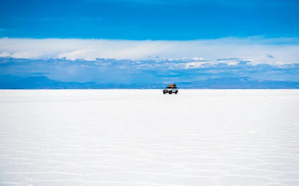 Sunshine táj Salar de Uyuni, Bolívia és autó — Stock Fotó