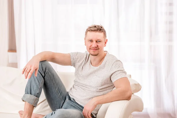 Homme assis sur le canapé dans la chambre — Photo