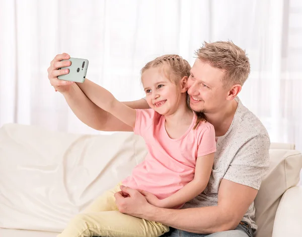 Padre e figlio si stanno facendo un selfie in salotto — Foto Stock