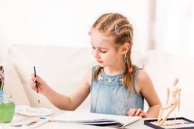 Küçük kız isdraws suluboya ile