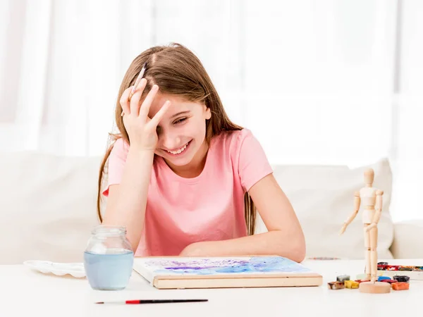 Adolescente sorri muito ao pintar — Fotografia de Stock