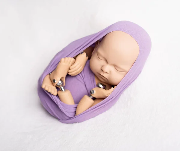 Doll of newborn kid in sling — Stock Photo, Image