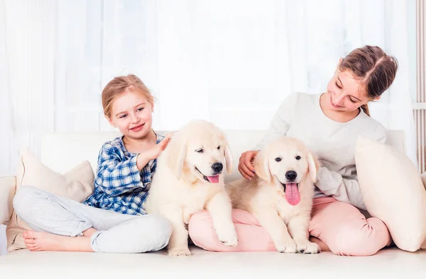 Lachende zussen zittend met puppy 's — Stockfoto