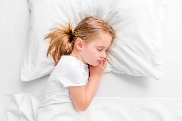 Beyaz yatakta uyuyan küçük kız — Stok fotoğraf