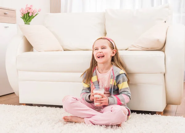 Bambina seduta con un bicchiere di latte — Foto Stock