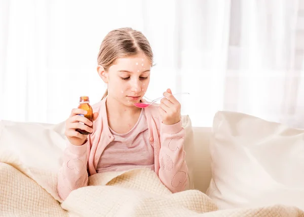 Menina adolescente tomando xarope para curar — Fotografia de Stock