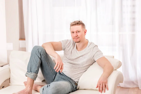 Man zit op de sofa in slaapkamer — Stockfoto