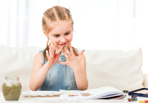 Child mixing colors at her hands — Stock Photo, Image