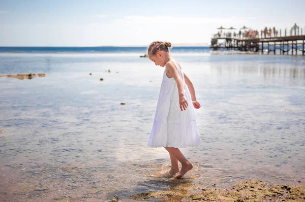 LIttle girl playing near water — Stock Photo, Image