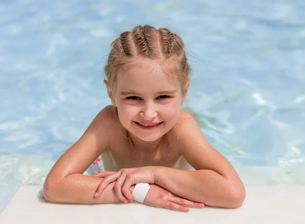 笑顔の少女はプールサイドに泳ぎます — ストック写真