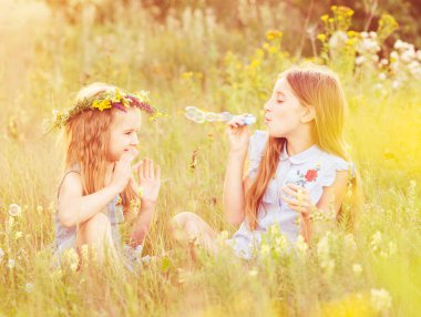 İki küçük kız kardeşi sabun köpüğü üfleme