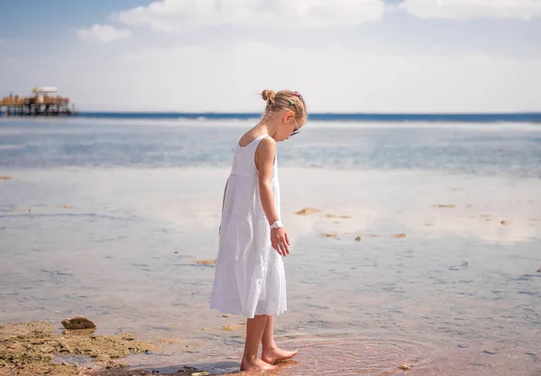 LIttle girl playing near water — Stock Photo, Image